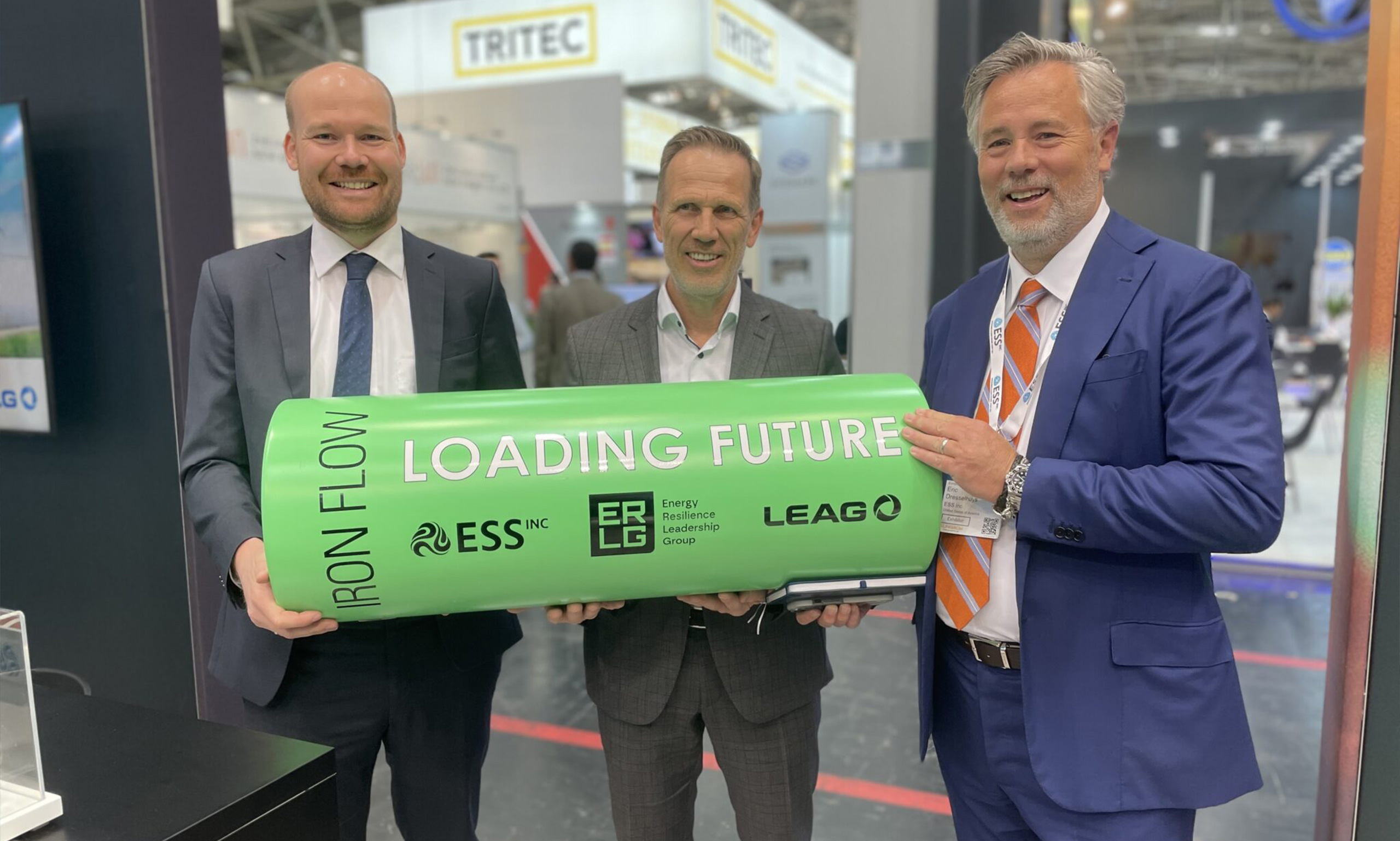 Philipp Offenberg (Breakthrough Energy), Eric Dresselhuys (ESS) and Thorsten Kramer (LEAG) in a group picture holding up a symbolic battery for their iron flow technology for long-duration storage of electricity.
